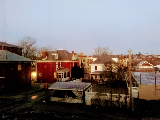 A view of a quiet neighborhood showcasing a variety of architectural styles at dusk.