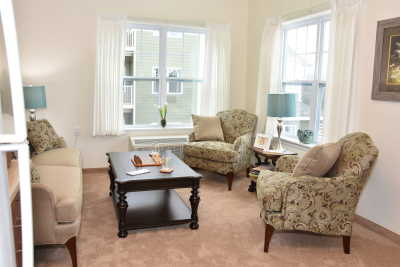 A cozy living room with patterned armchairs, a sofa, and a central coffee table.