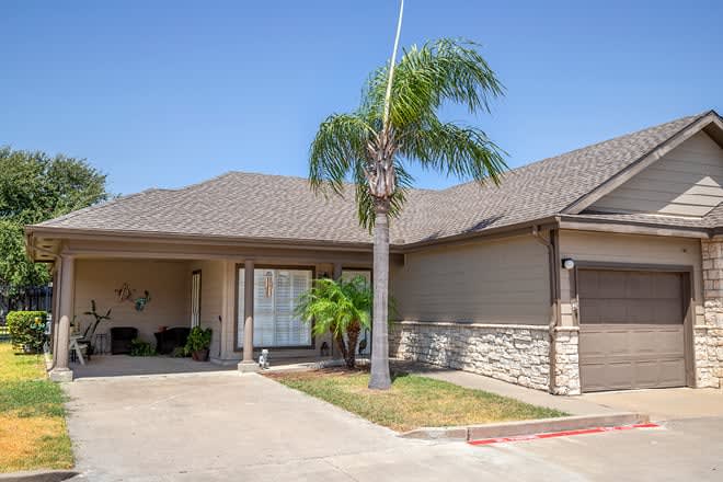 A suburban house with a palm tree in the front yard.