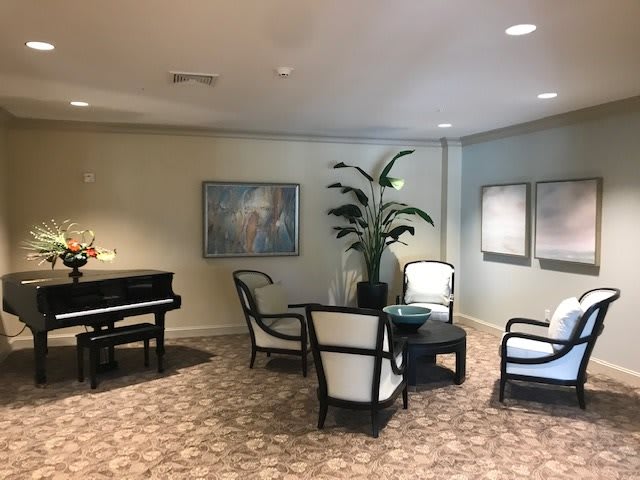 A cozy lobby area with elegant seating, a piano, and decorative artwork.