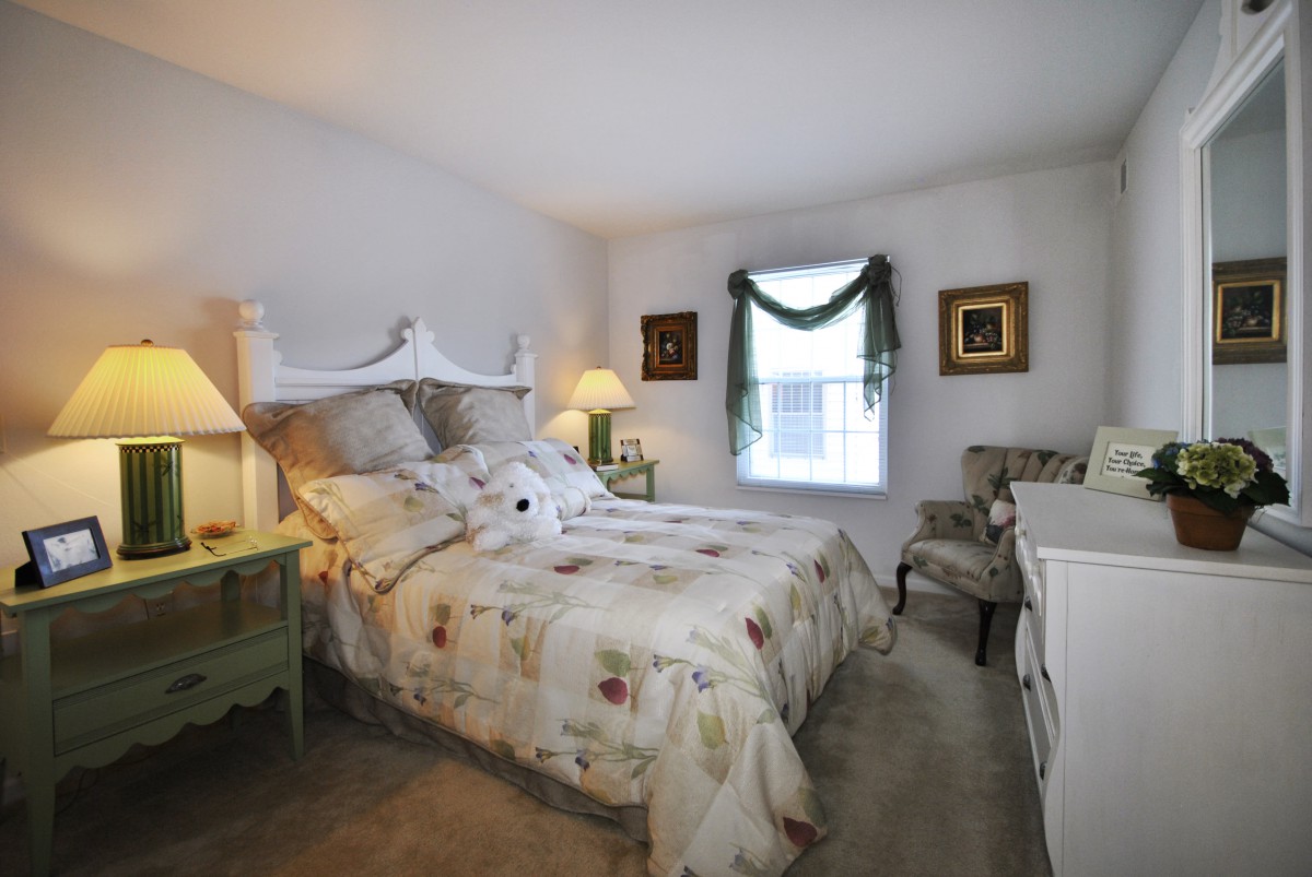 A cozy bedroom with a floral-themed bedspread and classic decor.