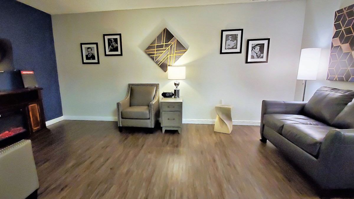 A cozy living room with armchairs and wall art.