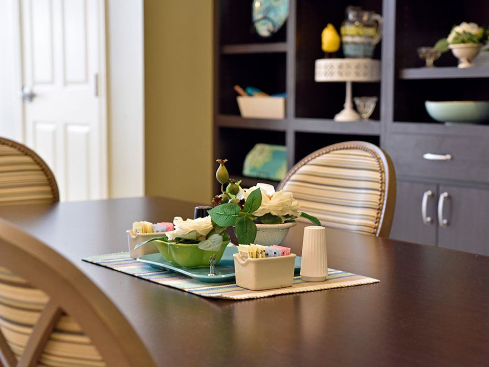 A beautifully set dining table with elegant decor and a flower arrangement.