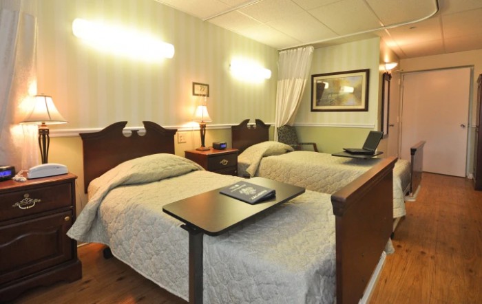 A cozy hotel room with twin beds, adorned with elegant decor and soft lighting.