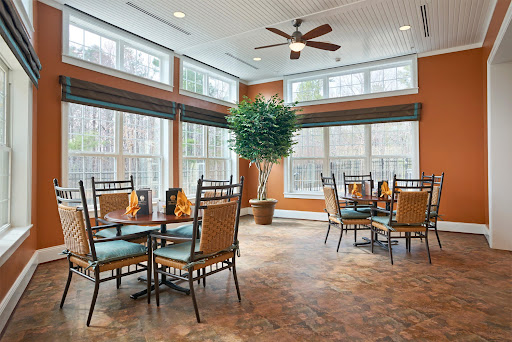 A bright and inviting dining area featuring modern furniture and large windows for natural light.
