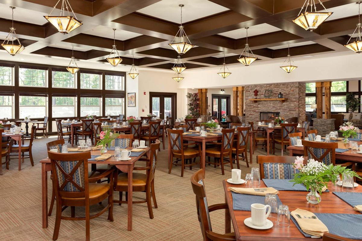 An elegantly decorated dining room with wooden furniture and neatly set tables.