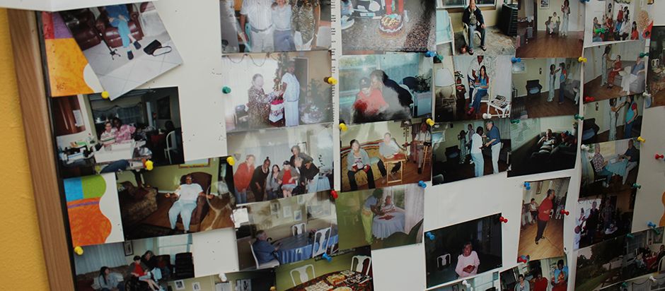 A nostalgic collage of family photographs pinned on a wall, capturing various memories and moments.