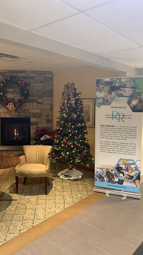 A warm and inviting space decorated for the holidays, featuring a beautifully adorned Christmas tree and a cozy fireplace.