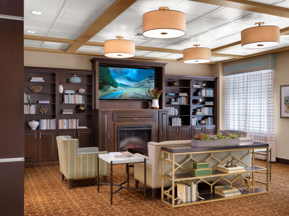A cozy living room with a fireplace, bookshelves, and comfortable seating.