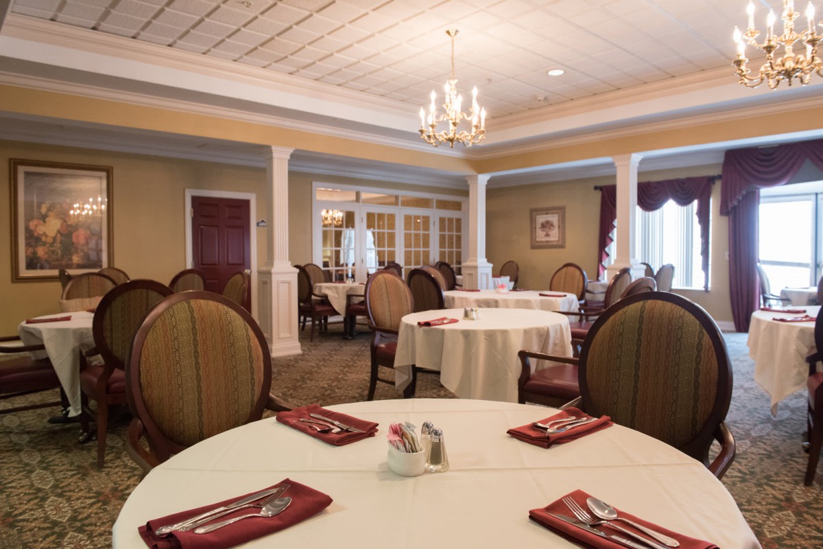 A spacious and elegantly decorated dining room with tables set for guests.