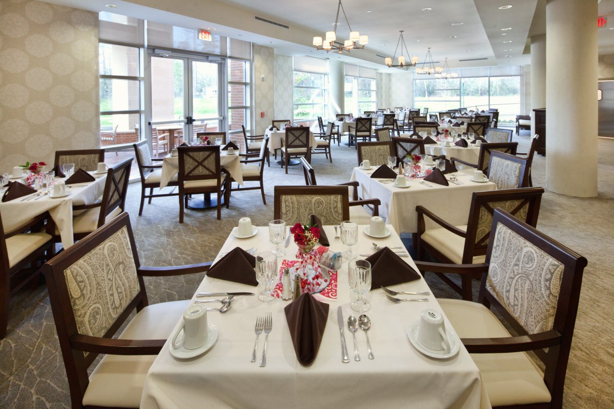 An elegantly set restaurant dining room with neatly arranged tables and chairs.