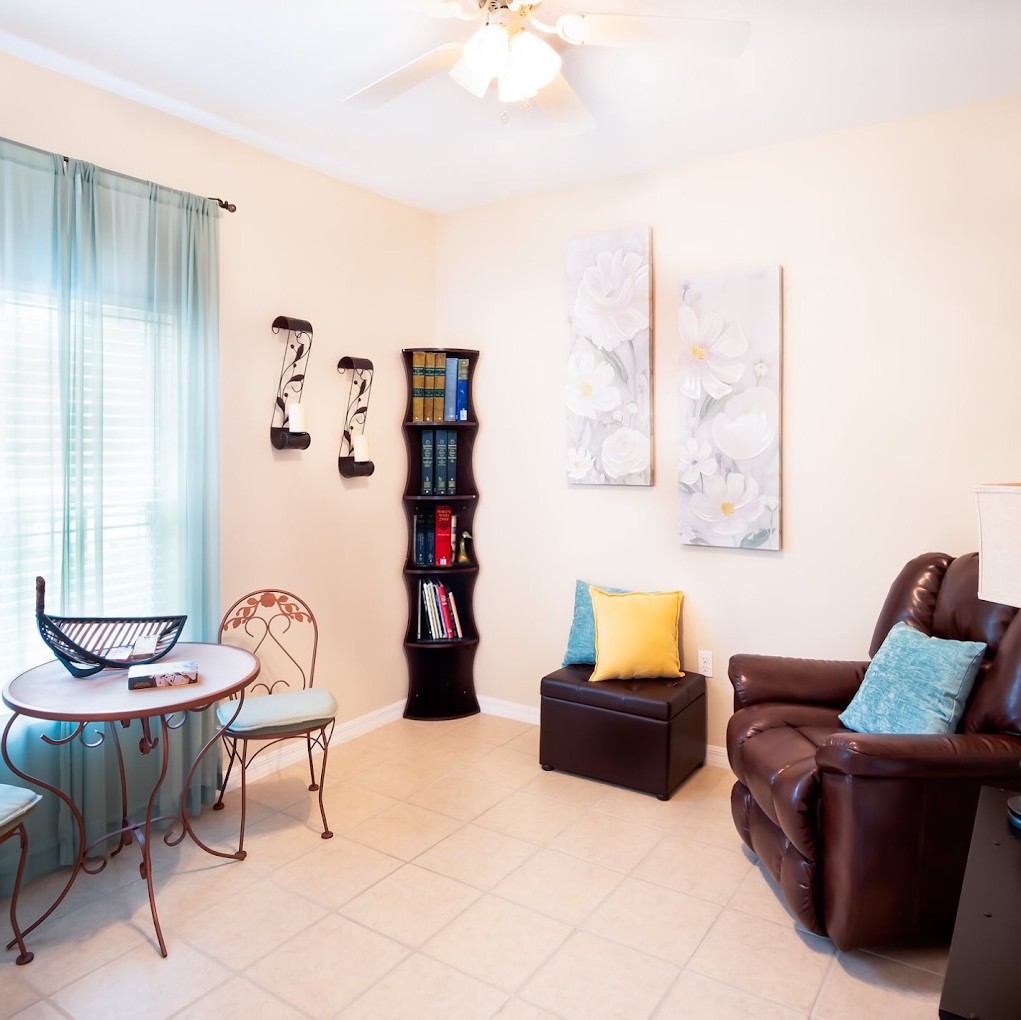 Cozy living room with a recliner, small table, and bookshelf.