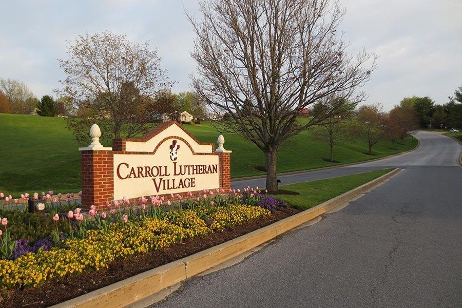 Entrance sign for Carroll Lutheran Village surrounded by landscaping.