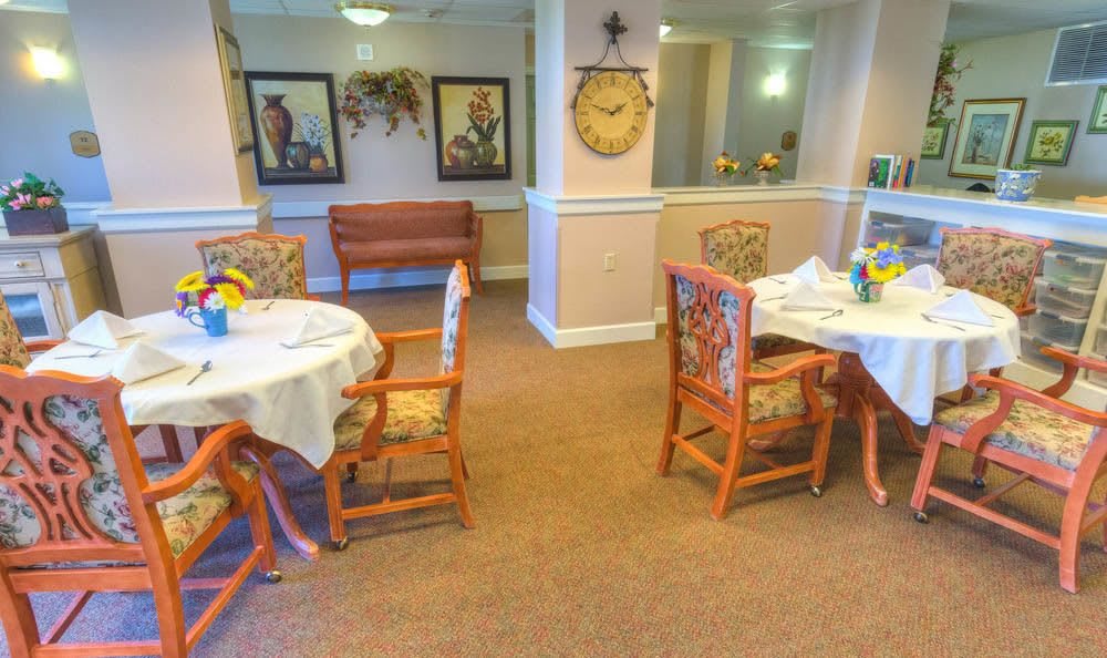 A cozy dining area featuring tables and chairs with decorative artwork on the walls.