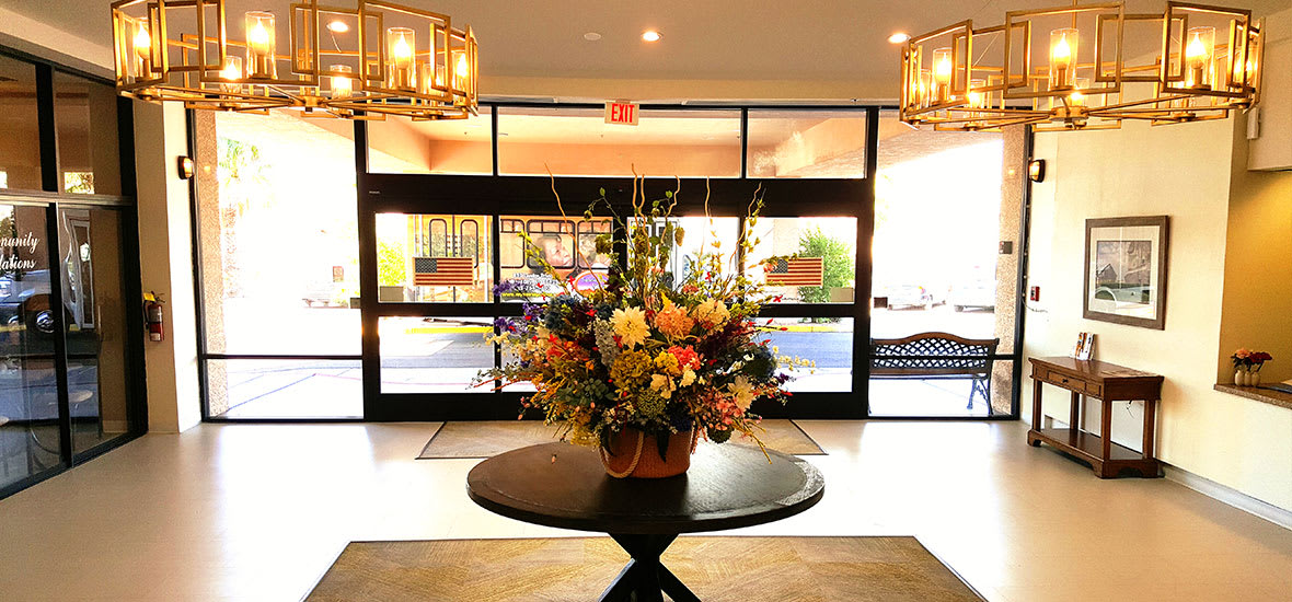 A beautifully decorated hotel lobby entrance with a floral arrangement on a central table.