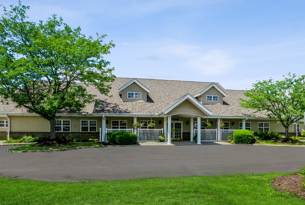 A suburban residential building with a neatly maintained lawn and trees.