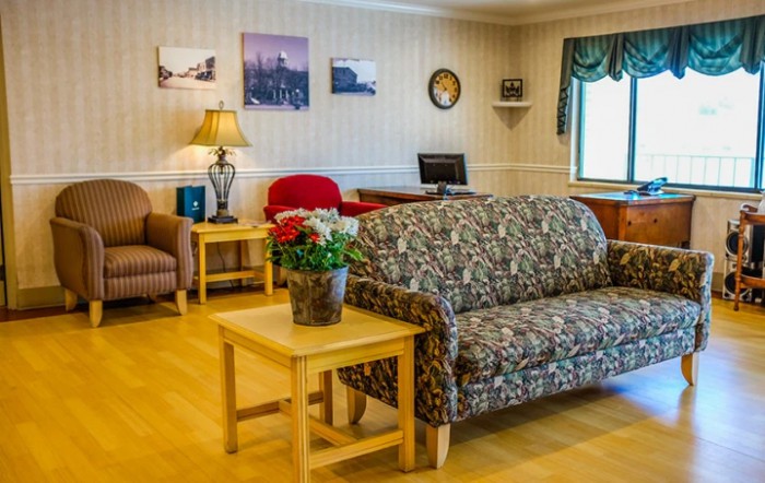 A cozy living room with various seating options, decor, and natural lighting.