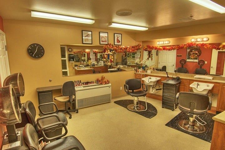 A cozy and decorated barbershop interior with chairs and mirrors.