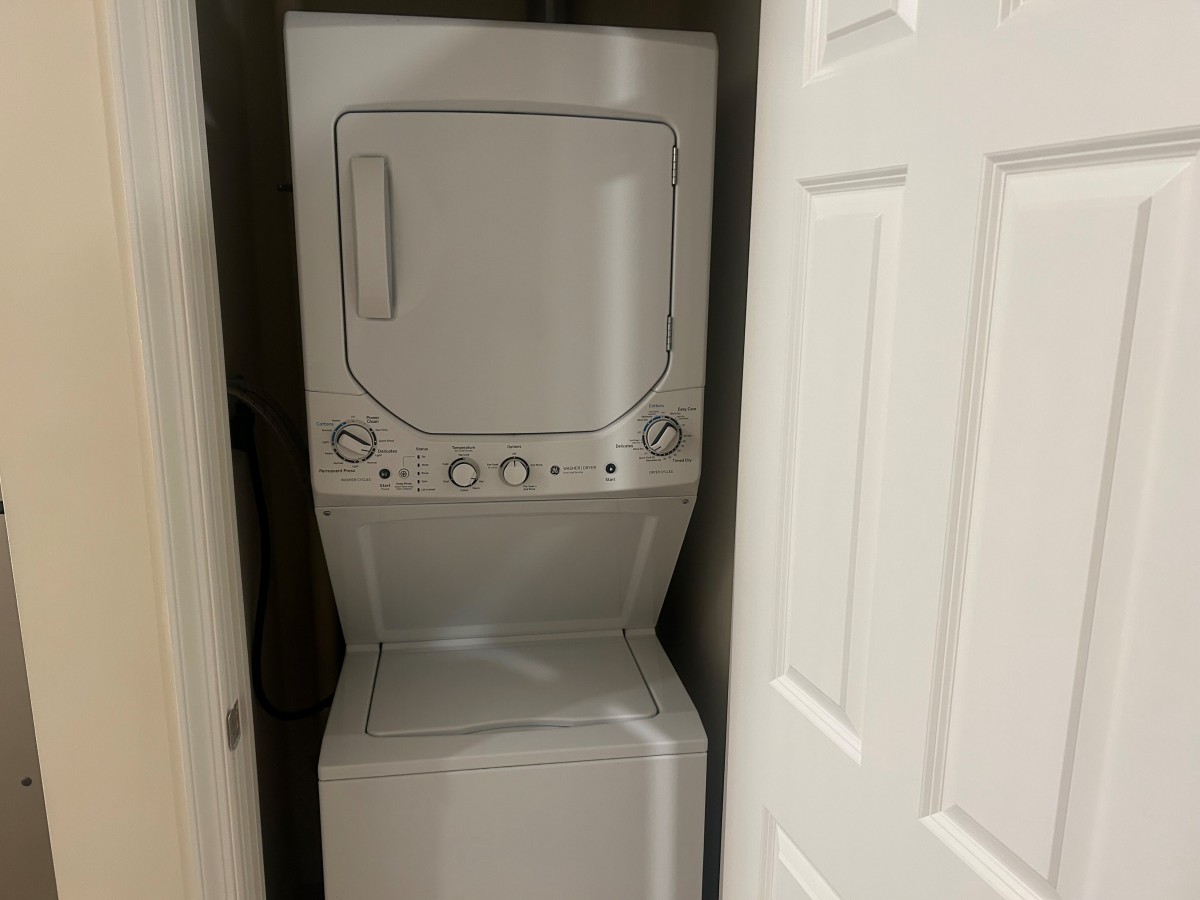 A stacked washer and dryer unit in a closet space.