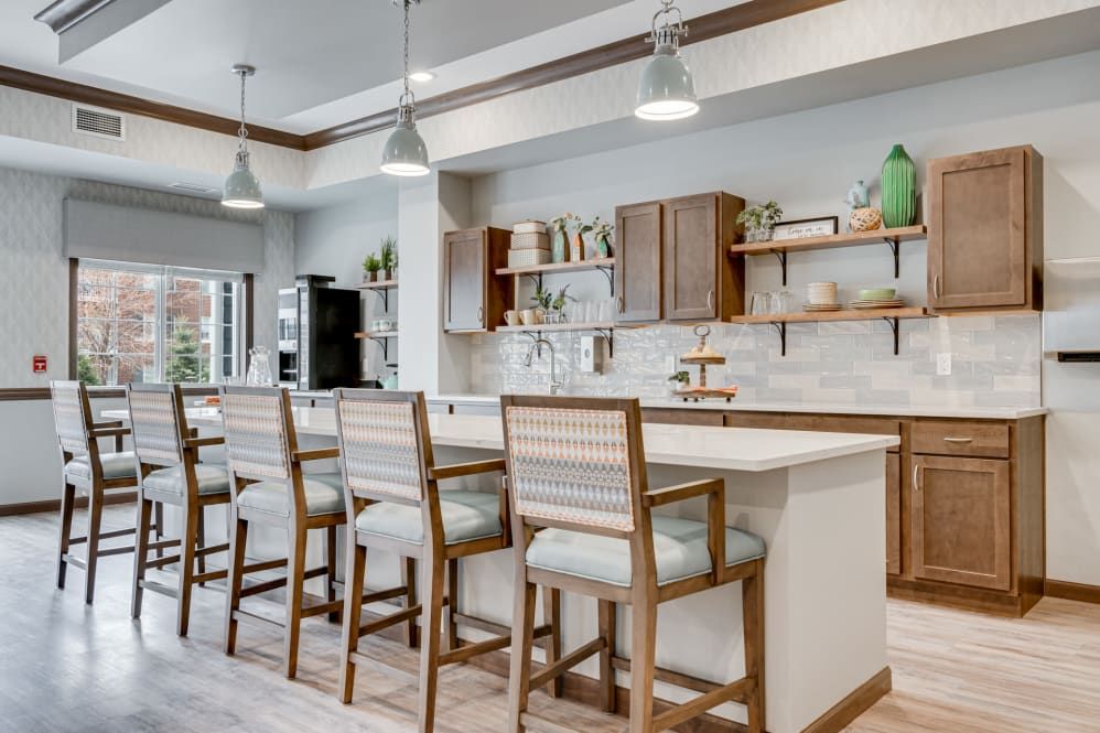 A modern kitchen featuring a central island with bar stools and open shelving.