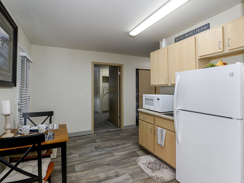 A modern kitchen with appliances and a dining area in an apartment.