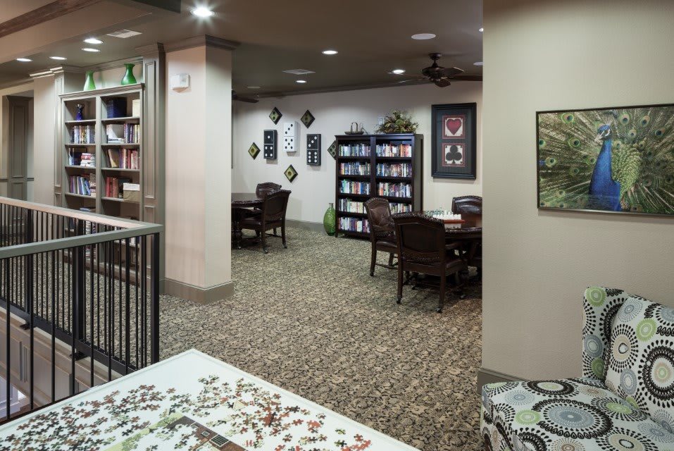A quiet library interior with bookshelves, tables, and chairs arranged for reading.