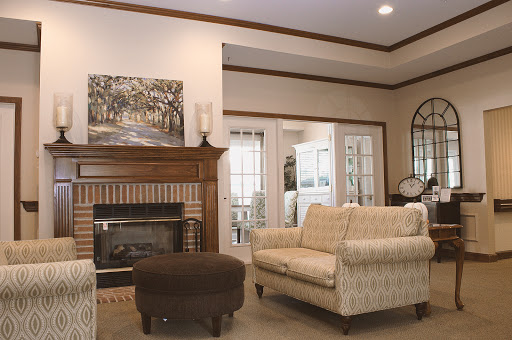 A cozy living room featuring comfortable seating, a fireplace, and tasteful artwork.