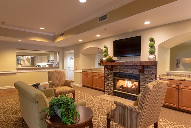 A cozy living room with a fireplace, TV, and comfortable seating.
