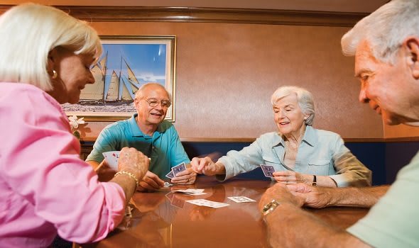 A group of seniors enjoying a game of cards together.