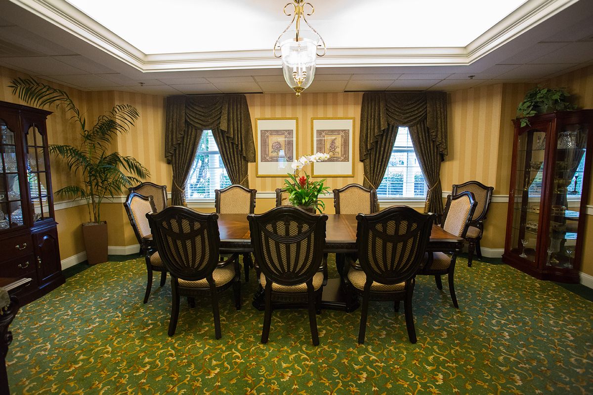 A well-decorated dining room with a large table, chairs, and elegant furnishings.