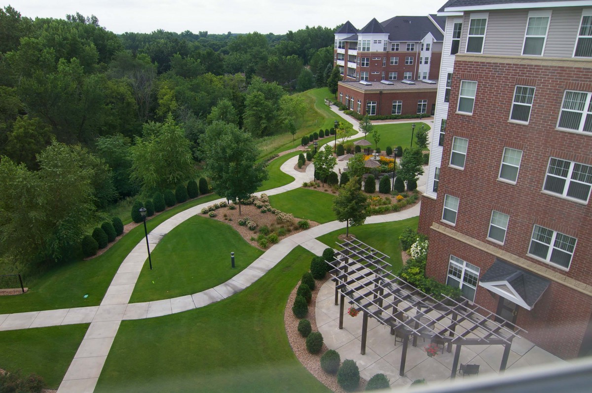 A scenic view of apartments with winding pathways and lush landscaping.