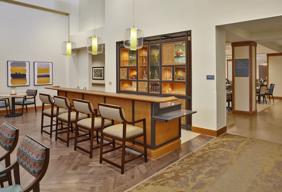A modern bar area with seating and stylish lighting fixtures.