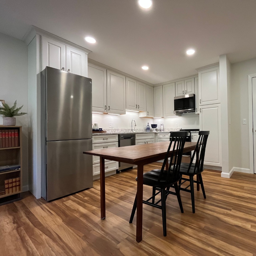 A modern kitchen with sleek appliances and a cozy dining area.