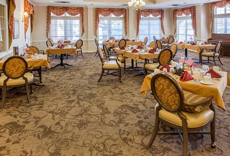 An elegantly decorated dining room with neatly arranged tables and chairs.