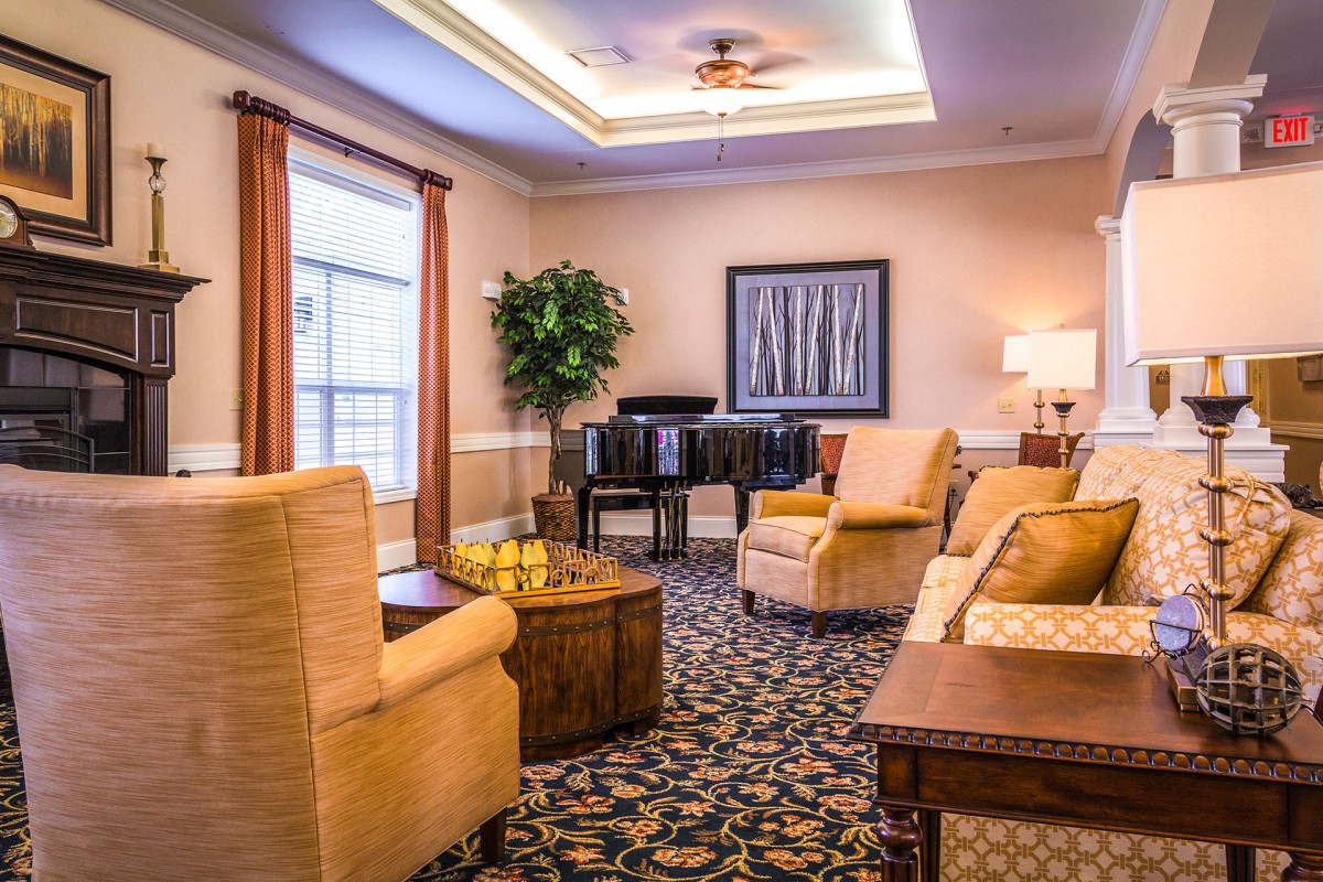 A cozy living room featuring plush seating, a piano, and elegant decor.