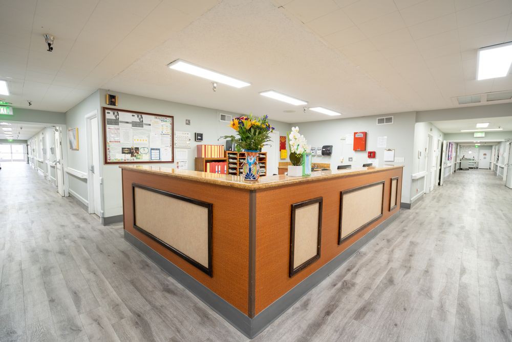 A tidy reception desk with flowers and office supplies.