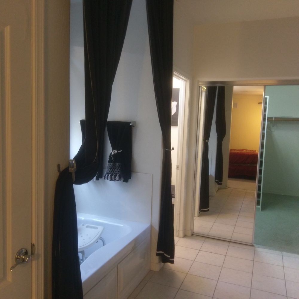 A modern bathroom interior with a bathtub and curtains.