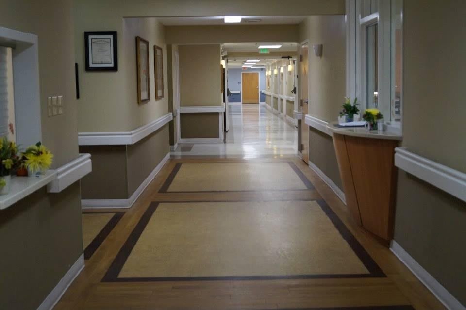 An empty hospital corridor with clean floors and lighting.