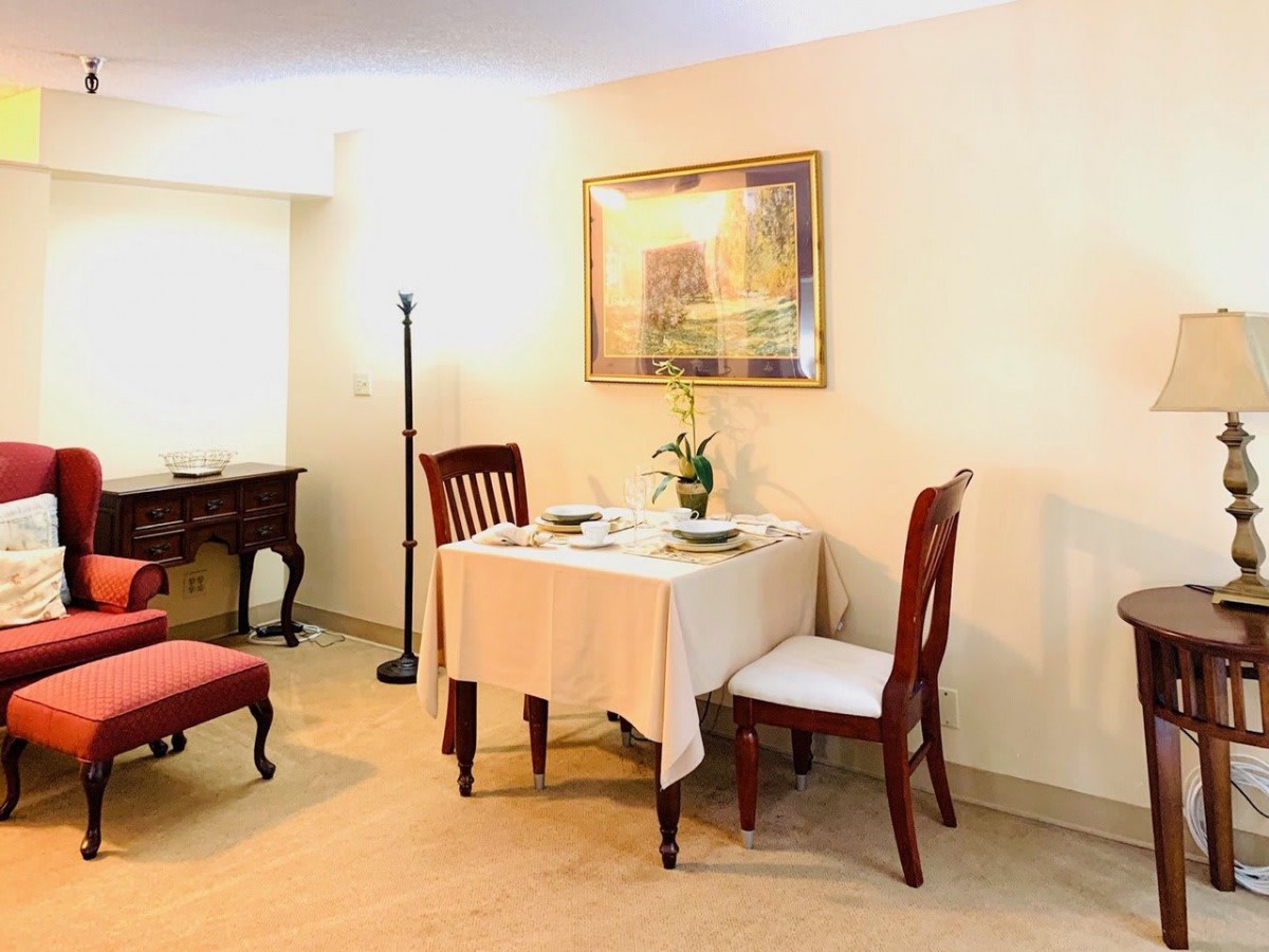A cozy dining area with a small table set for two, complete with elegant chairs and soft lighting.