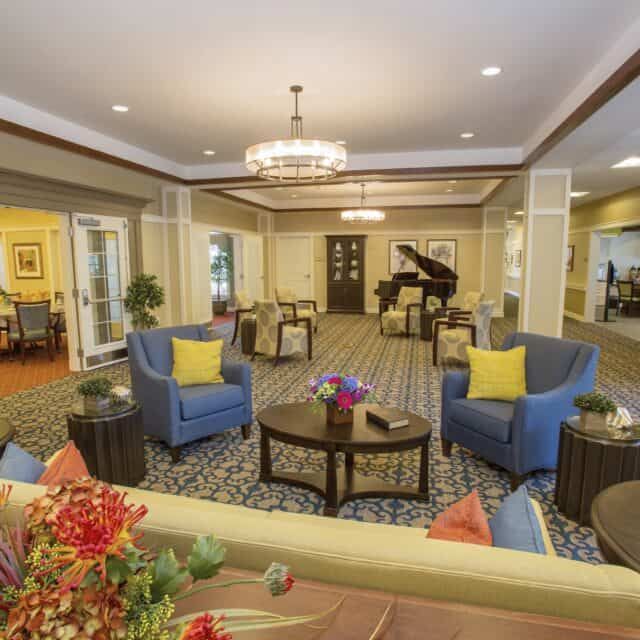 A cozy lounge area featuring comfortable seating and a piano.