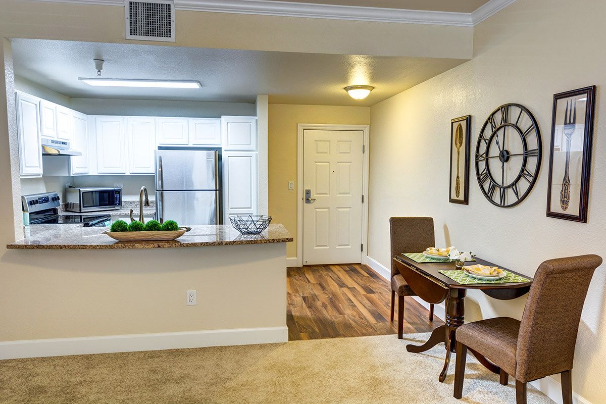 A modern apartment interior featuring a kitchen and dining area with contemporary decor.