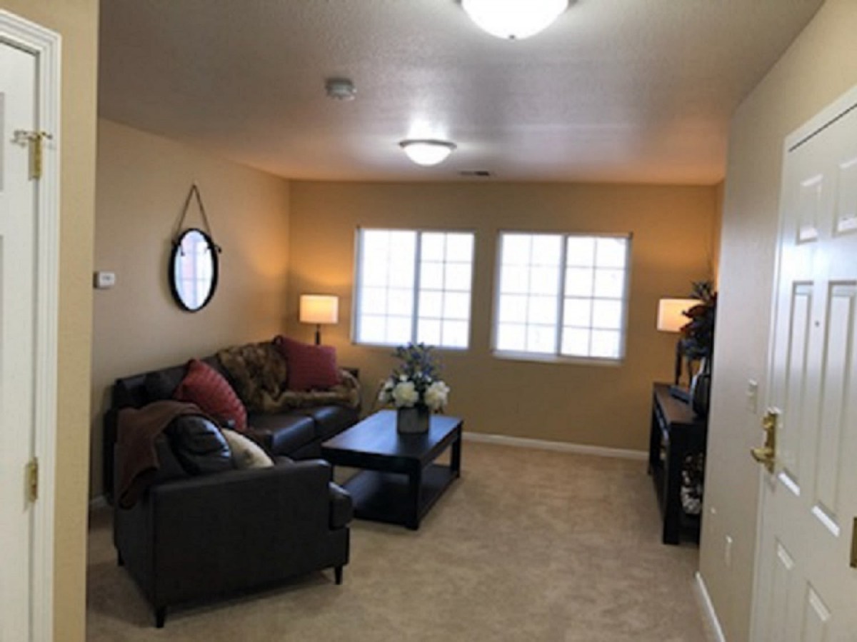 A cozy living room with a sofa, coffee table, and soft lighting.