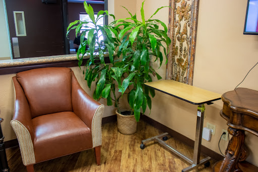 A cozy corner featuring a comfortable chair, a small table, and a vibrant indoor plant.
