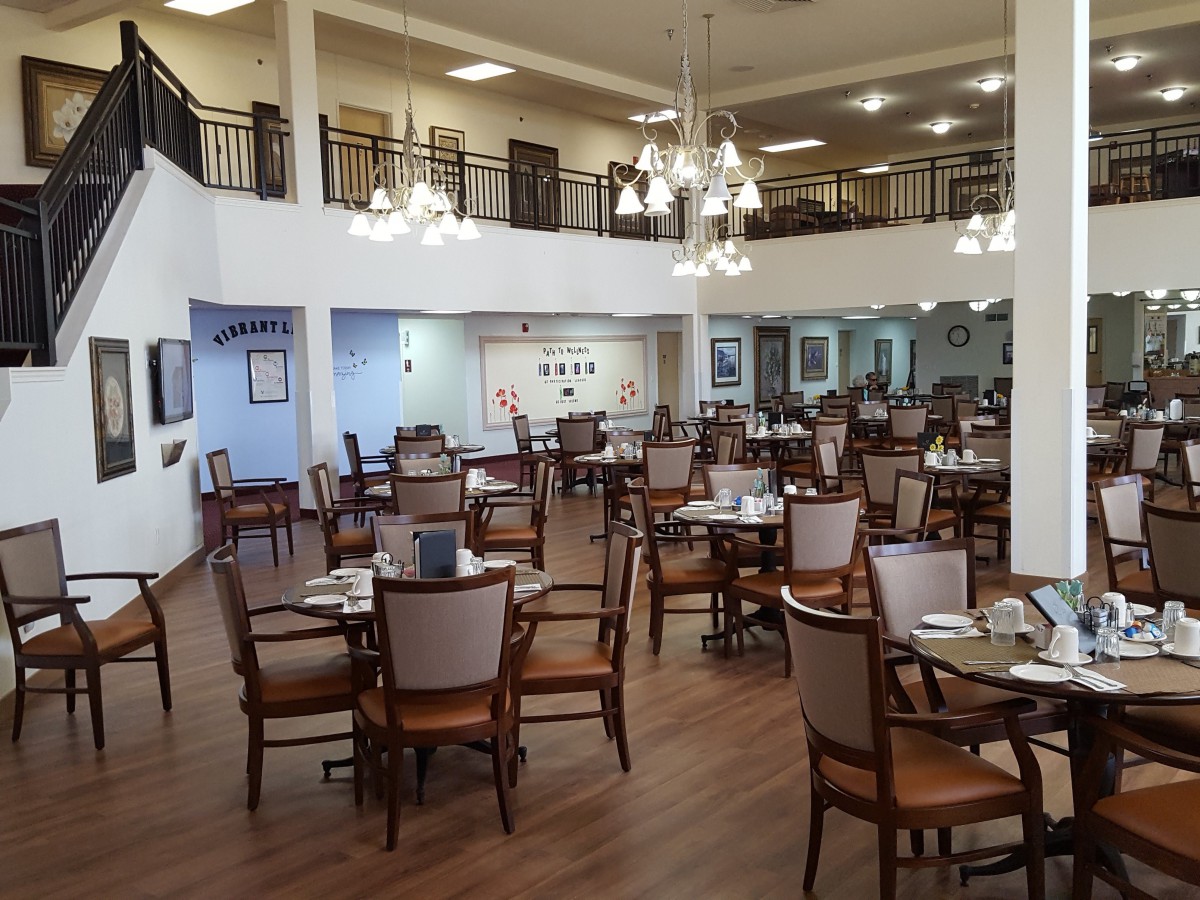 Spacious dining area with elegant chandeliers and neatly arranged tables.