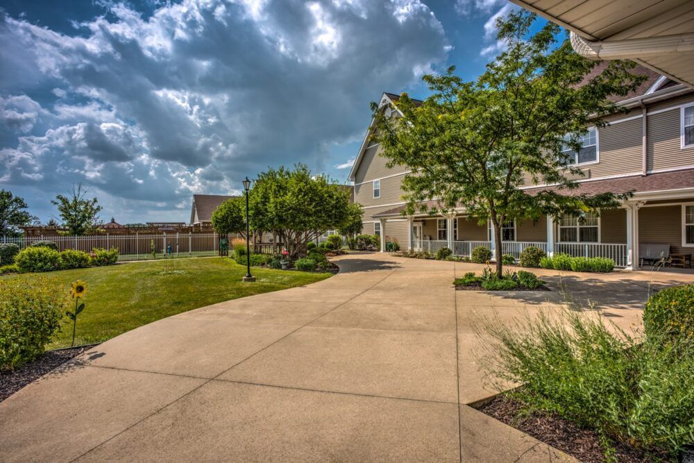 A picturesque suburban home with a well-maintained driveway and landscaped garden under a cloudy sky.