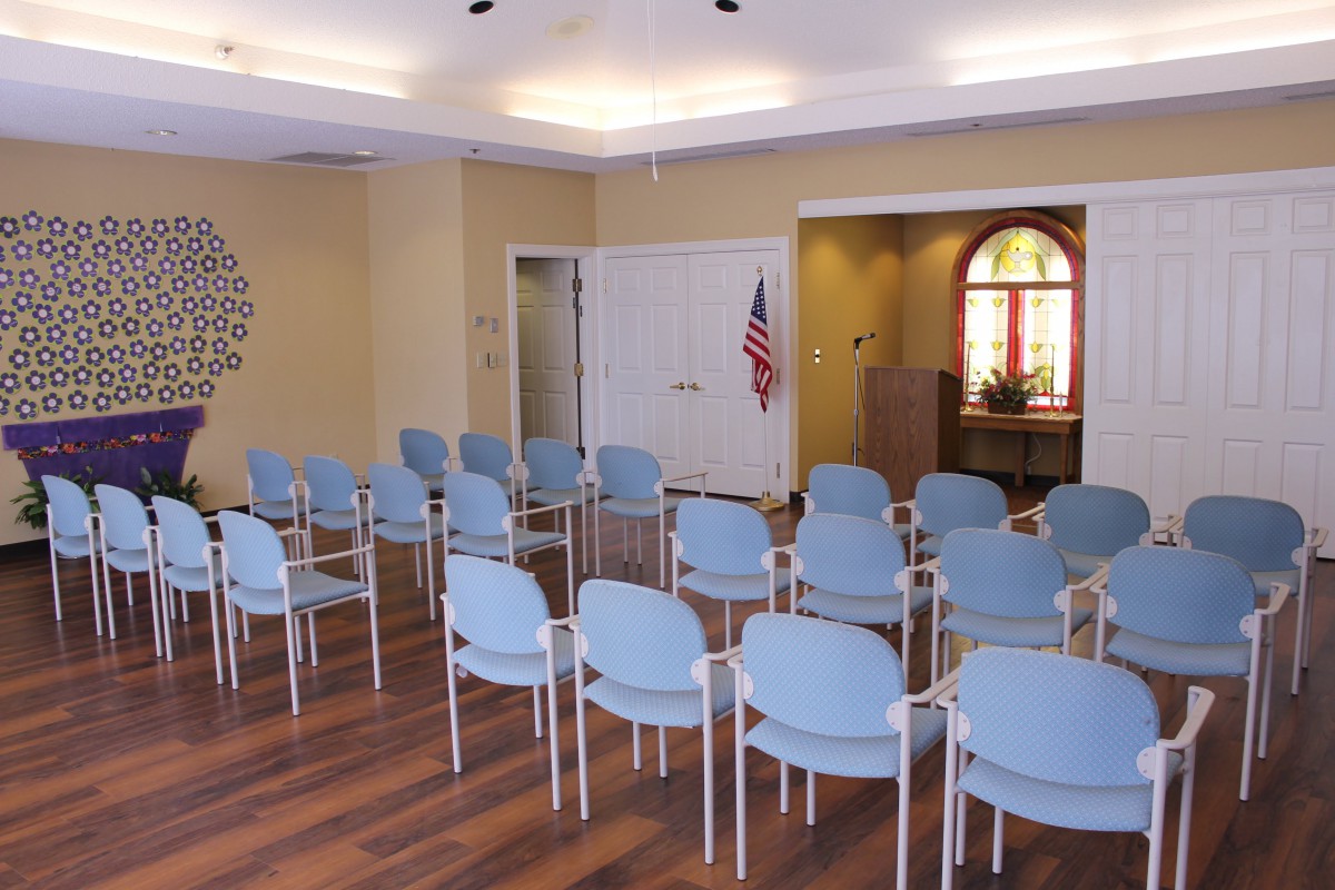 An empty meeting room with rows of chairs arranged for a conference.