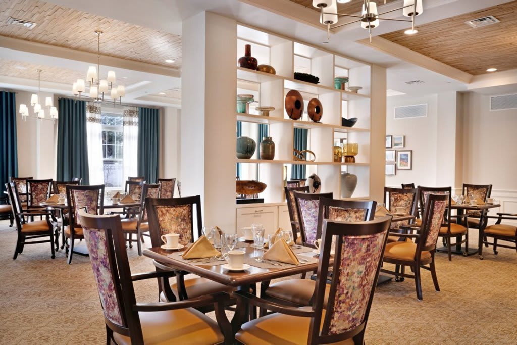 An elegantly designed dining area with decorative shelves and stylish furniture.