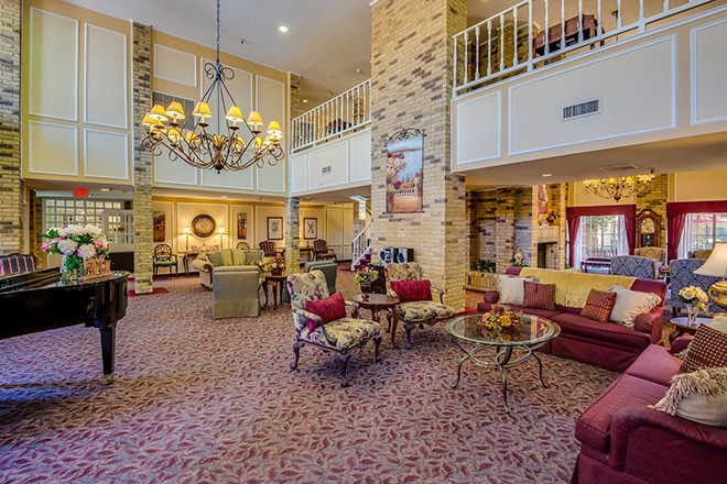 A spacious hotel lobby with elegant decor, featuring a large chandelier and comfortable seating areas.