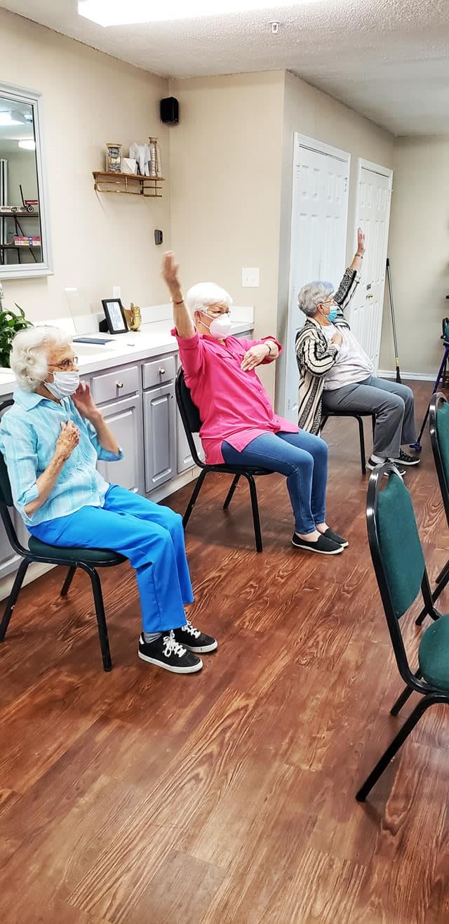 Seniors participating in a chair exercise class together indoors.