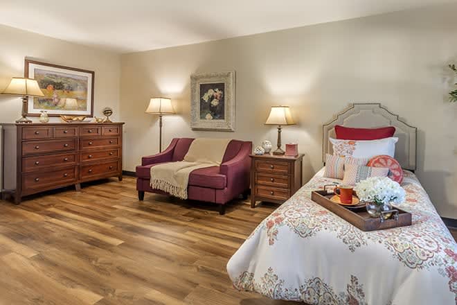 A cozy bedroom with elegant furniture and warm lighting.